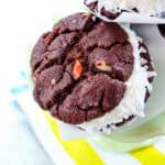 A closeup of a chocolate cookie ice cream sandwich with the edges rolled in coconut.