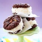 Three ice cream sandwiches piled on a cake stand with text overlay that says "Chocolate Coconut Ice Cream Sandwiches".