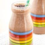 A smoothie in a glass bottle with rainbow stripes on the side with text overlay that says "Chocolate Mint Smoothie".