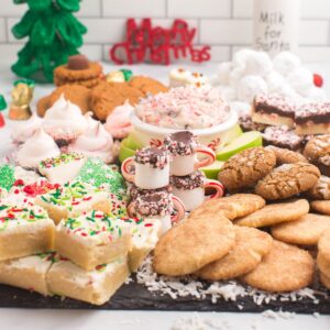 A slate board piled with gluten free Christmas cookies and other treats.
