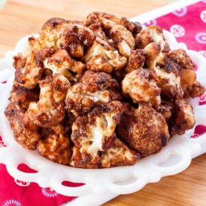 Cranberry Balsamic Glazed Cauliflower florets on a white dish.