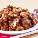 A white plate with a pile of cranberry balsamic cauliflower bites.