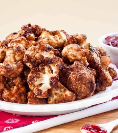 A white plate with a pile of cranberry balsamic cauliflower bites.