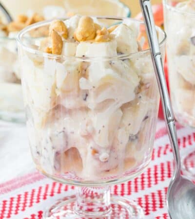 A glass dish of apple candy bar salad with a spoon leaning against it.