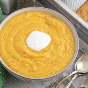 A bowl of vegetable soup garnished with greek yogurt.