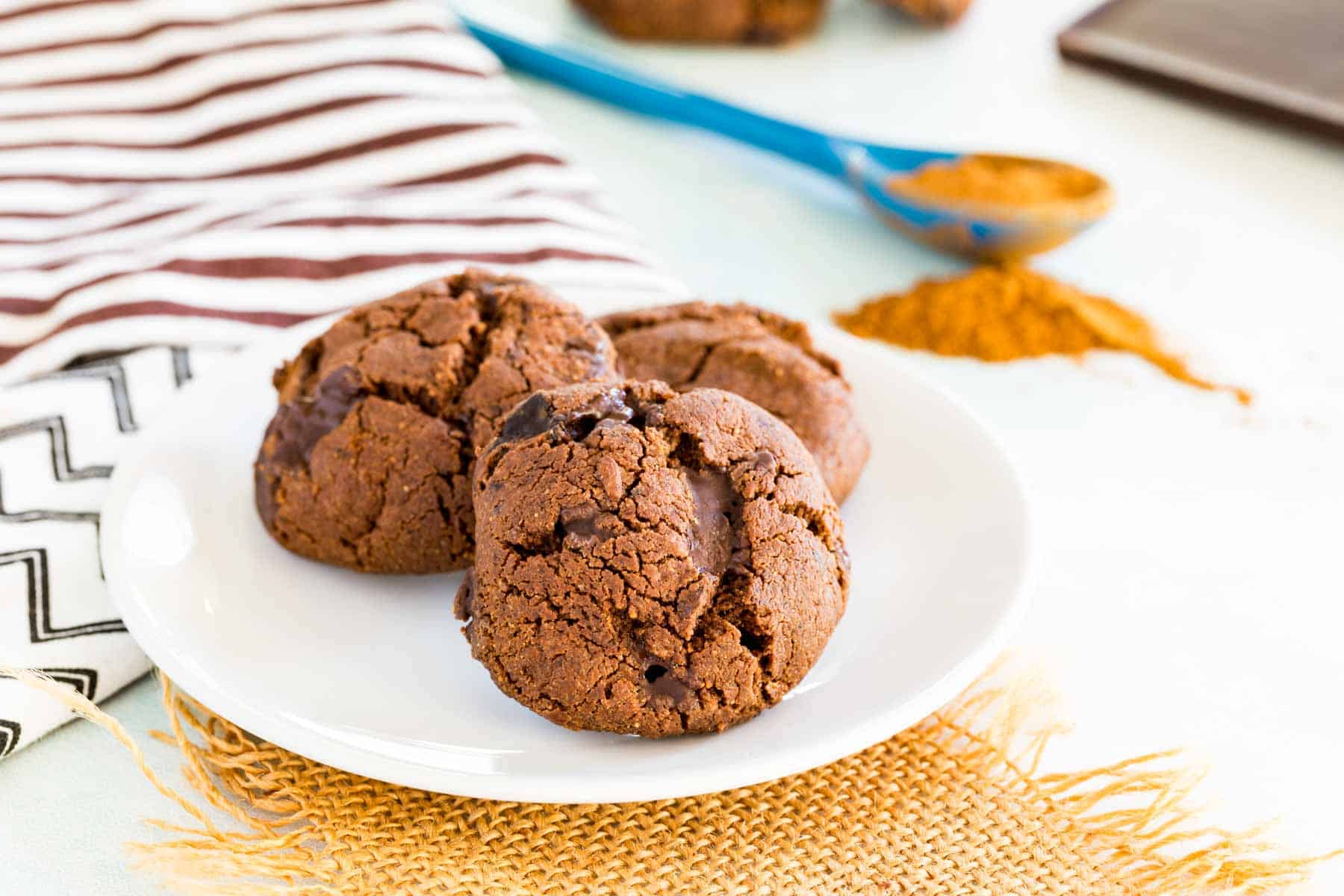 Flourless Spicy Chocolate Cookies with cinnamon, ginger, and cayenne mix in the background.