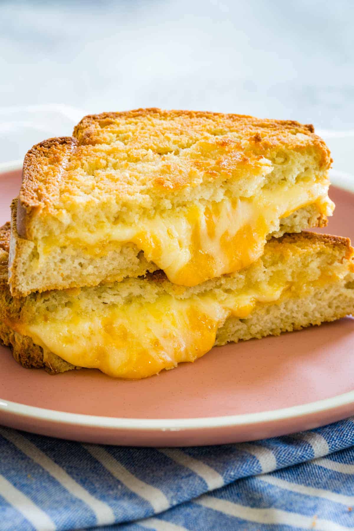 Cheese melts out of two stacked halves of an air fryer grilled cheese.