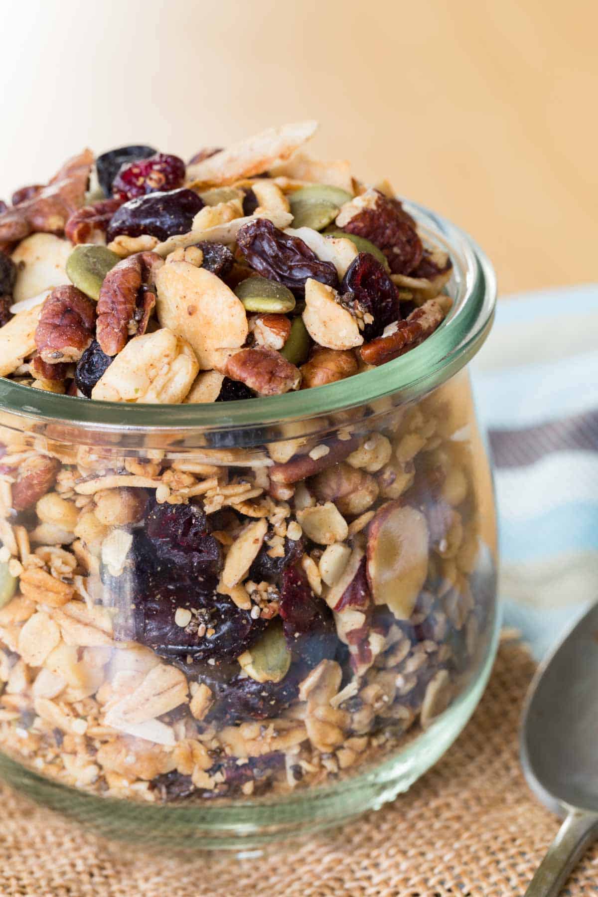 A jar of granola with oats, nuts, and dried fruit.