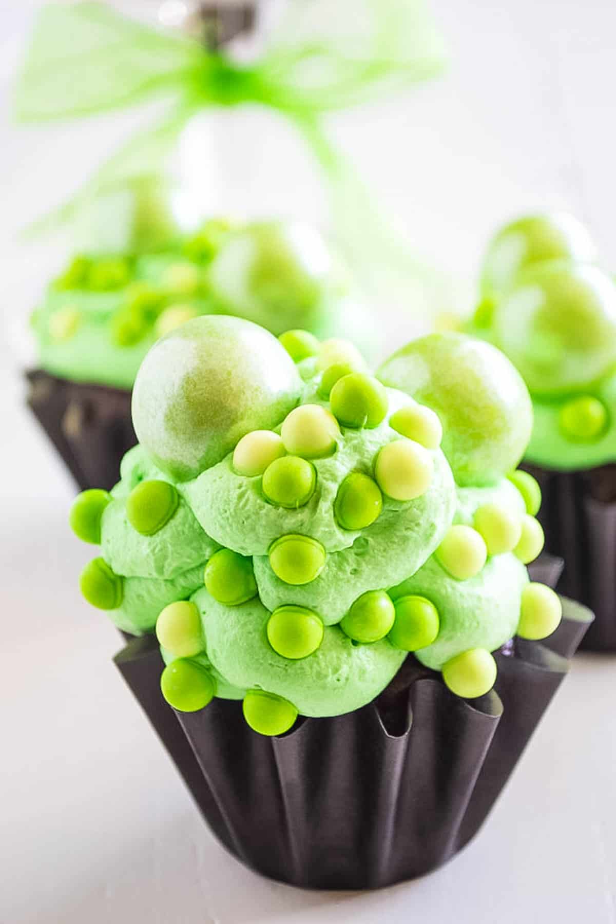 A chocolate cupcake decorated to look like a cauldron of a green potion.