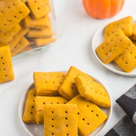 rectangluar gluten free pumpkin cookies on plates and in a jar with a black and white checked cloth napkin.