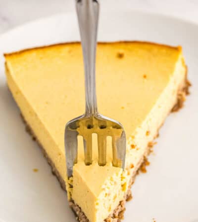 A small dessert fork going into the tip of a slice of gluten free pumpkin tart.