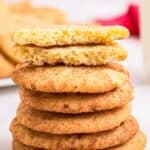 A stack of cookies with one broken in half on top to show the interior texture with text overlay that says "Gluten Free Snickerdoodles".