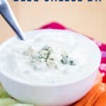 A bowl of creamy dip topped with blue cheese crumbles with text overlay that says "Greek Yogurt Blue Cheese Dip".