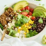 A Beef Burrito Bowl on a White Countertop Beside a White Dish Towel.