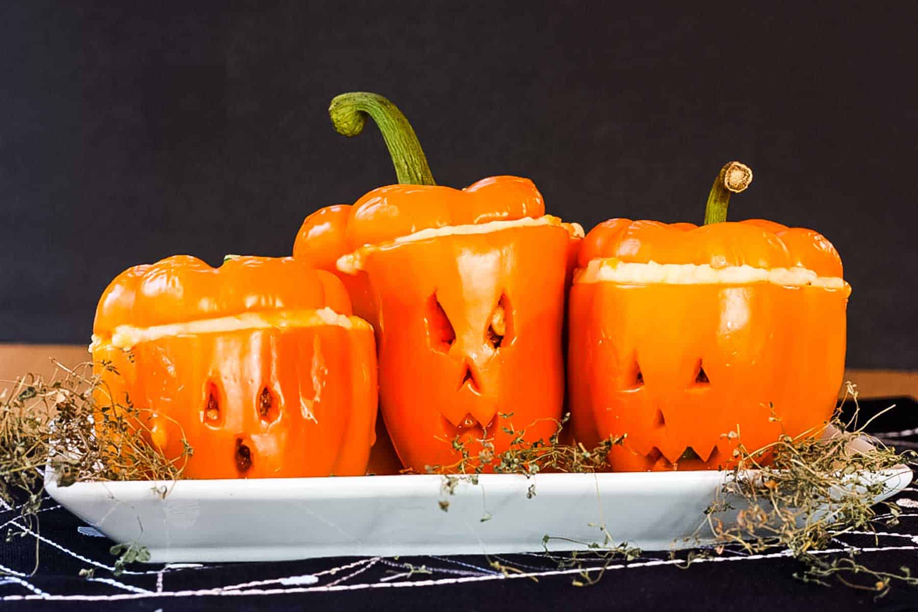 Shpeherds Pie Stuffed Peppers carved like Jack O'Lanterns on a plate.