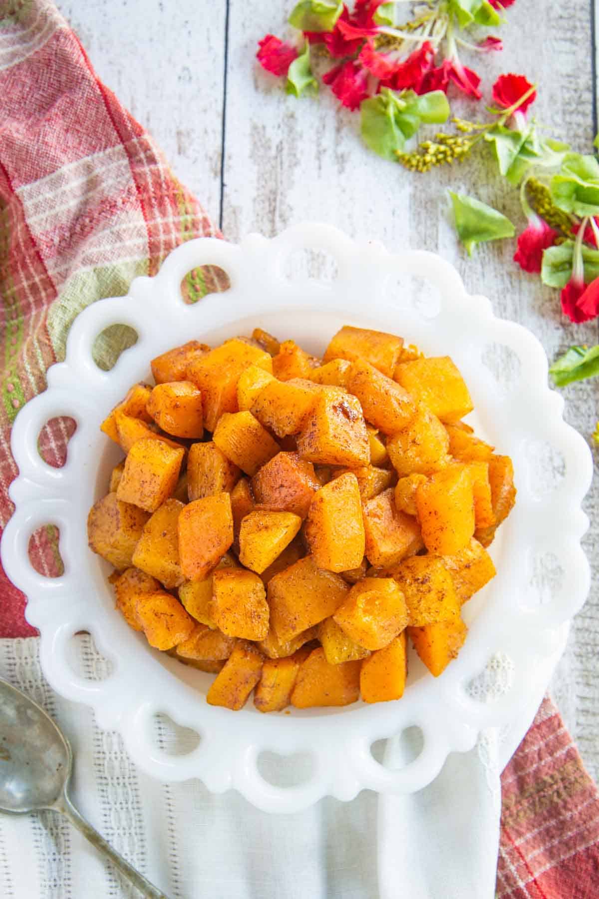 Looking down on a plate of cubes of roasted butternut squash.