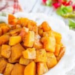 Cubes of roasted squash on a white plate with text overlay that says "Honey Roasted Butternut Squash".