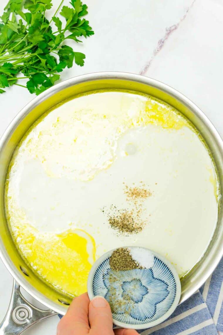 A pot of cream and butter is shown with a bunch pf parsley.