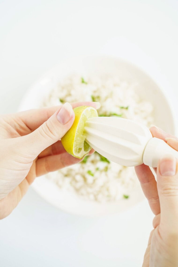 juicing a lime into a bowl of rice
