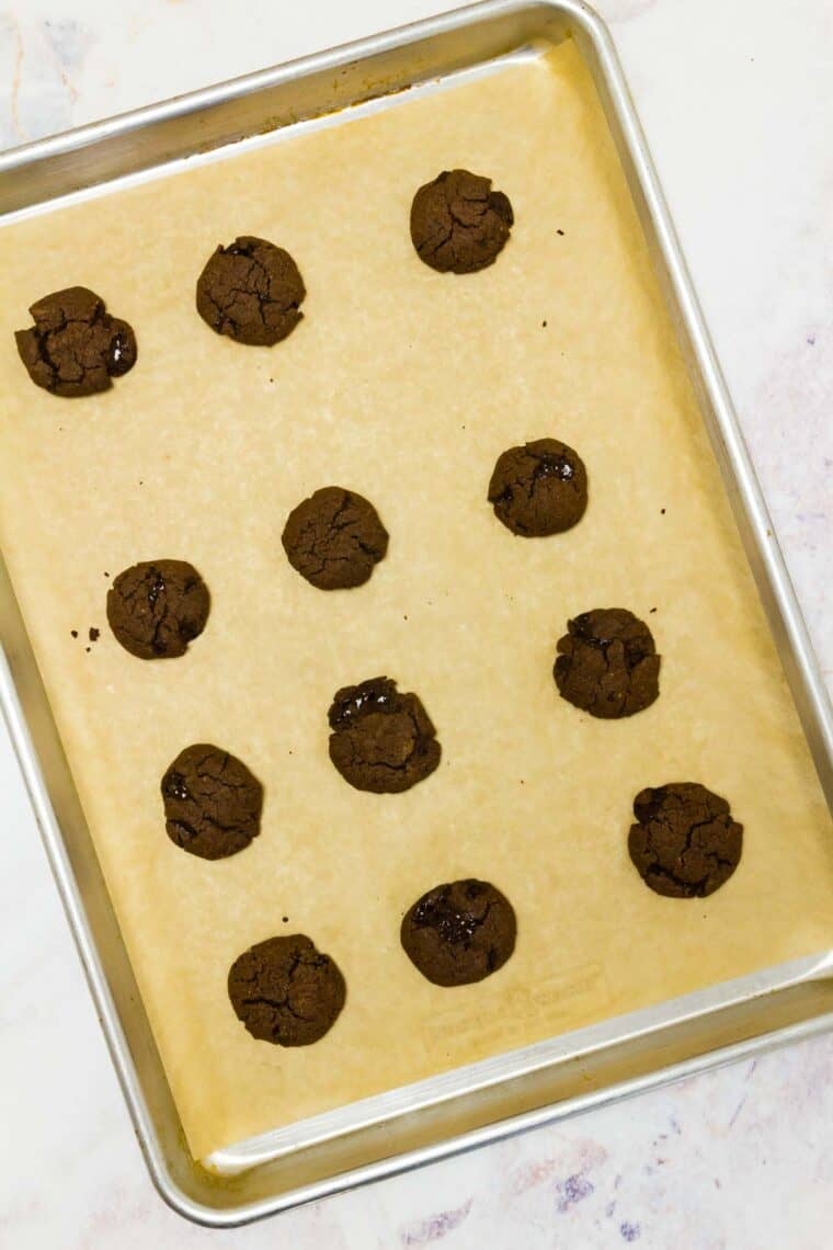 Baked cookies on a sheet pan lined with parchment paper.