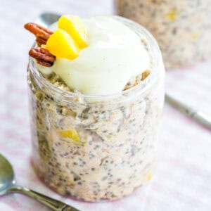 Hummingbird Cake Overnight Oats in a jar topped with yogurt and a couple of pieces of pineapple and pecans.
