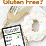 A bagel smeared with cream cheese on a plate with text that says "Is Cream Cheese Gluten Free?" and an overlay of a tablet with text that says "All the info, and recipes to make with it."