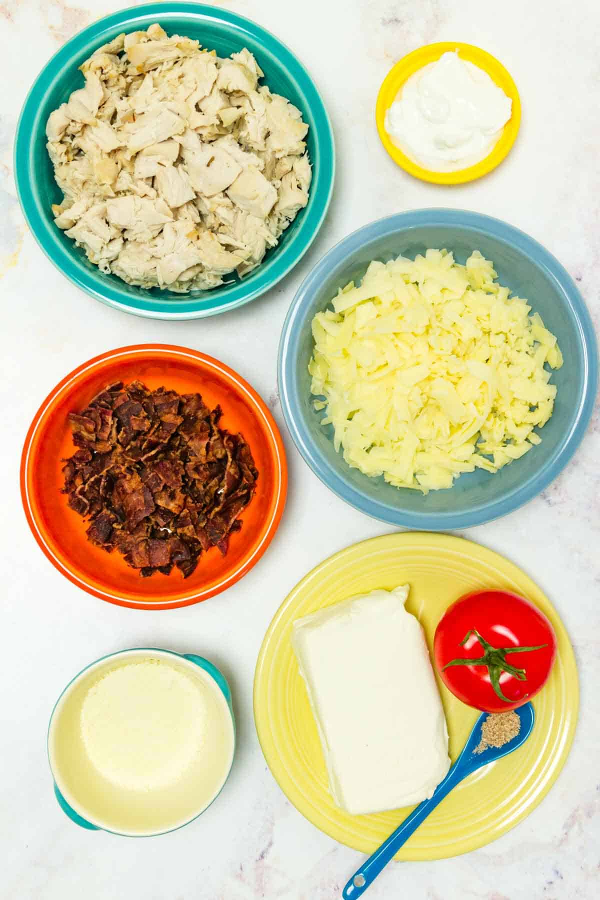 All of the ingredients to make the dip recipe in bowls and on a plate.