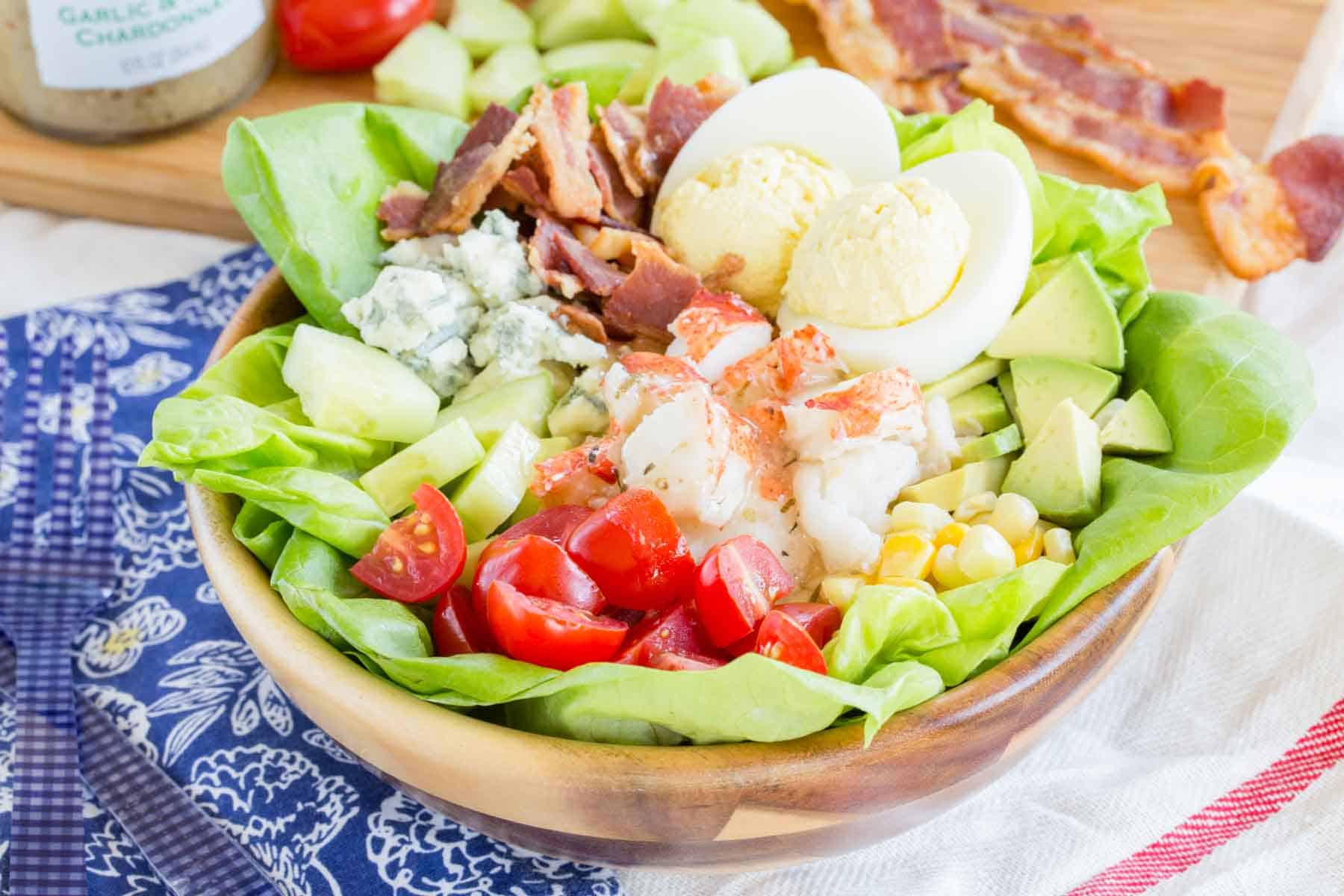 A salad with lobster bacon, tomatoes, lettuce and eggs.