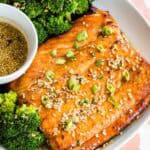 Broiled salmon on a plate with maple sesame glaze and broccoli.