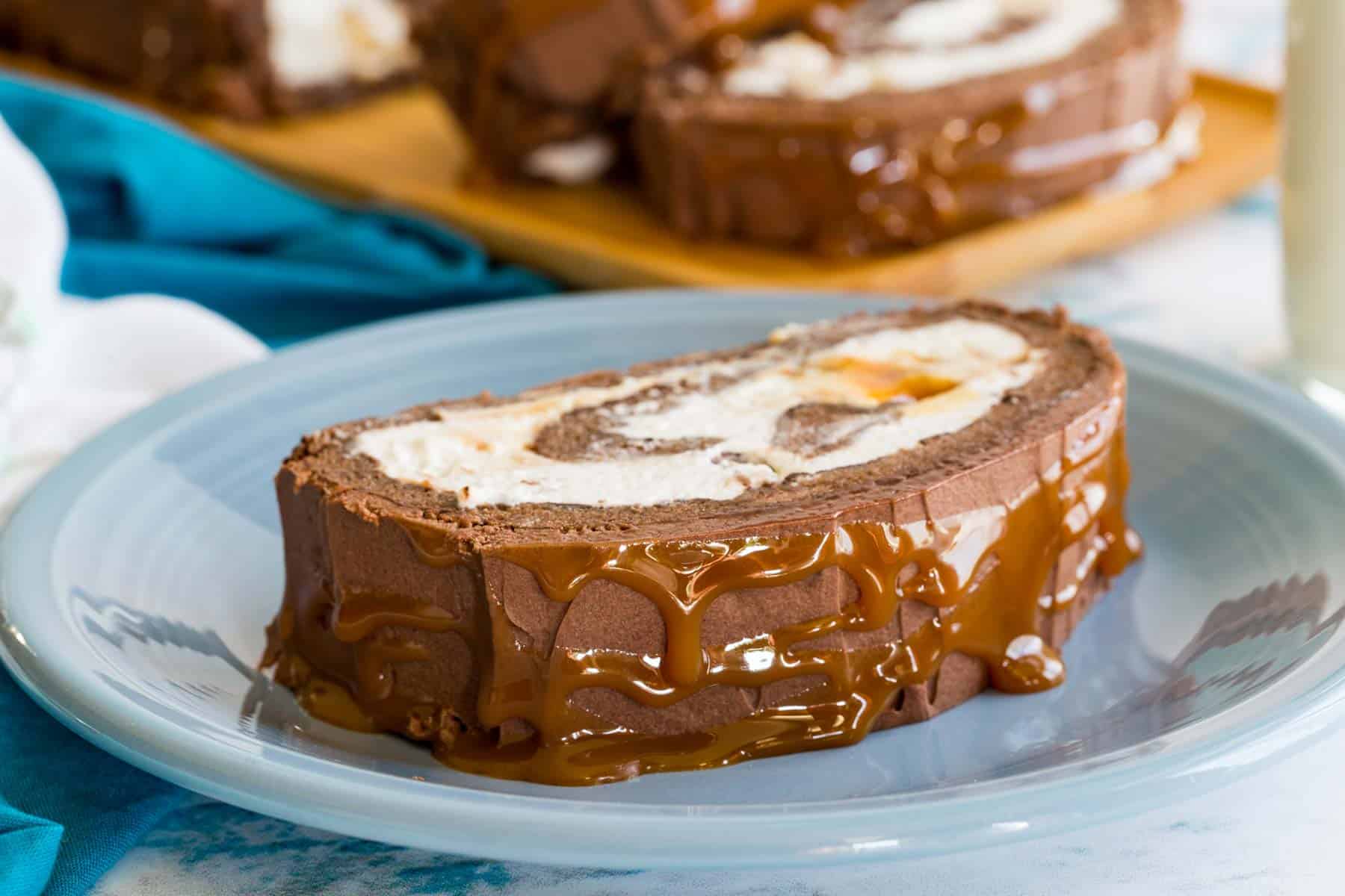 A slice of Caramel Swiss Roll on a blue plate.