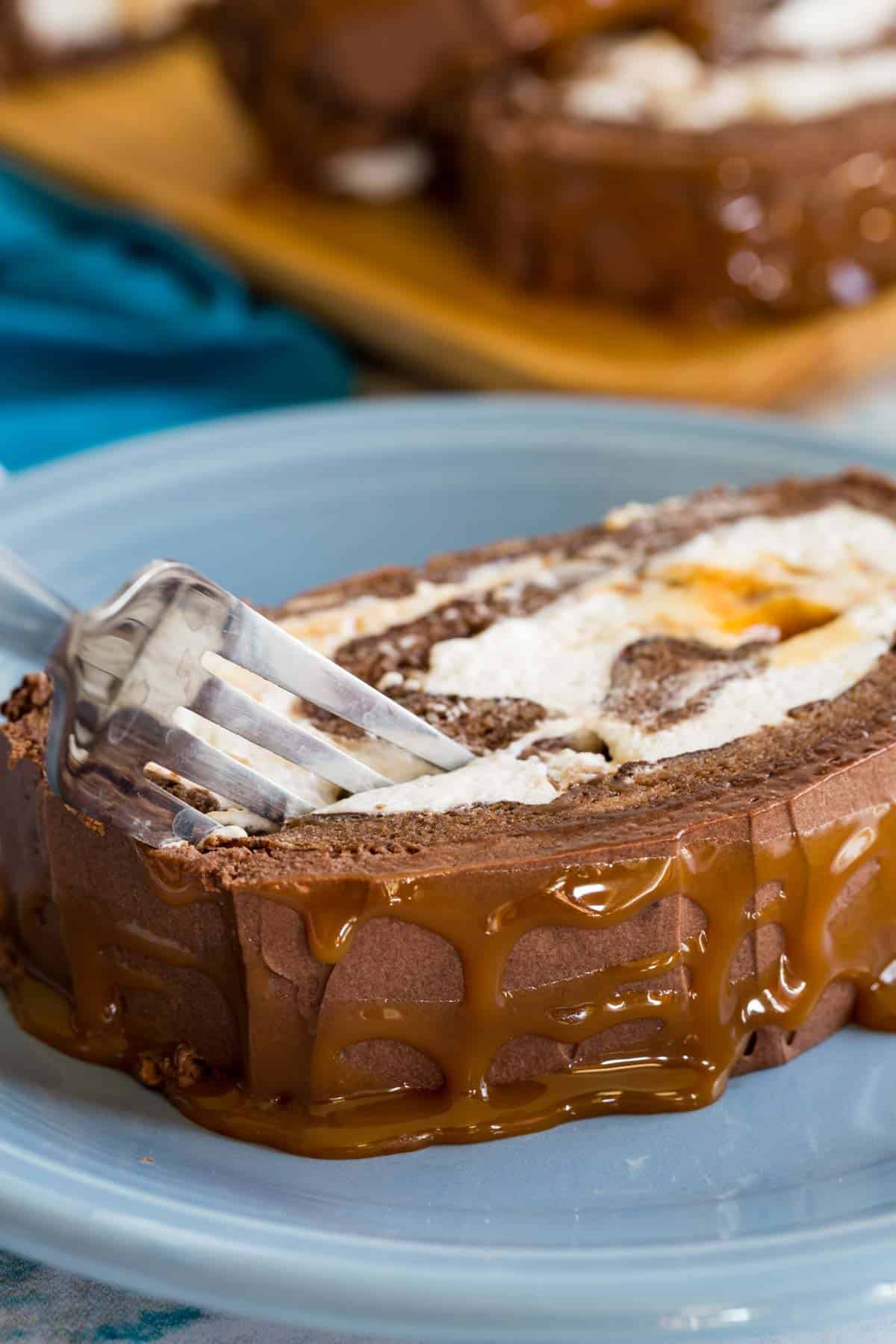 A fork cutting into a piece of Caramel Swiss Roll.
