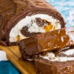 Looking at the inside of a Flourless Caramel Chocolate Cake with whipped cream and Milky Ways.