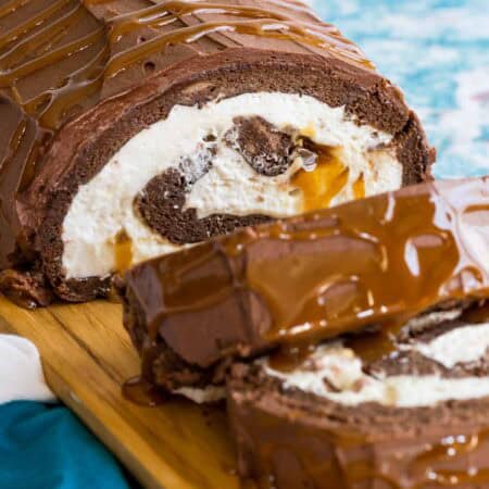 Looking at the inside of a Flourless Caramel Chocolate Cake with whipped cream and Milky Ways.