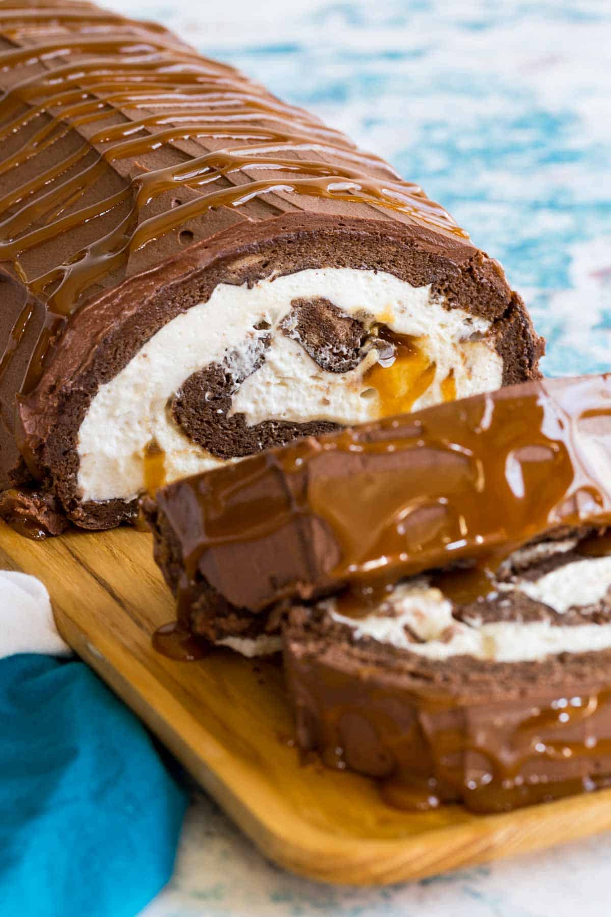Looking at the inside of a Flourless Caramel Chocolate Cake with whipped cream and Milky Ways.