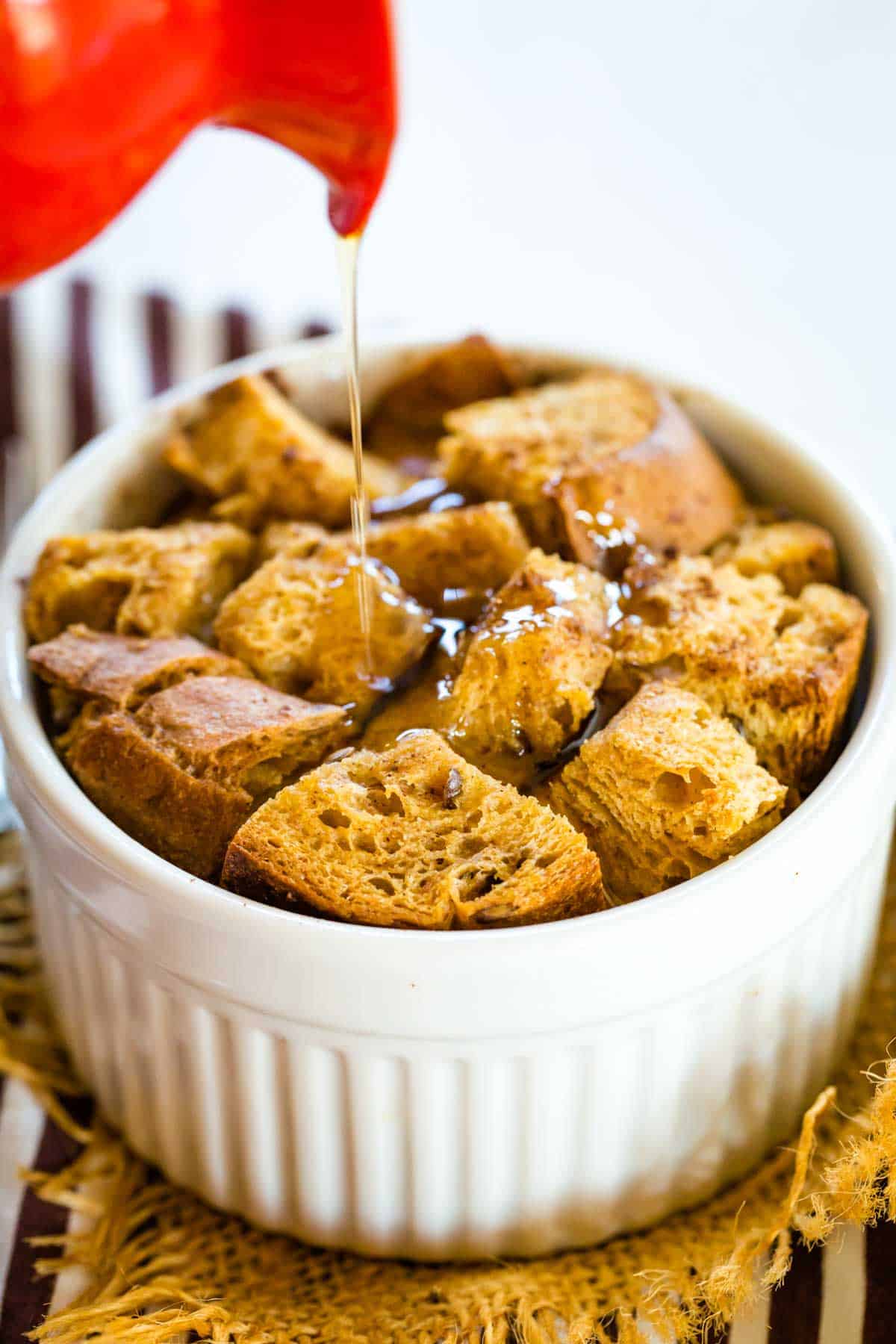 Drizzling syrup on an Individual Gluten Free French Toast Breakfast Casserole.