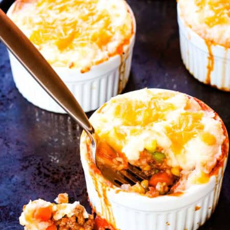 Some of the beef and potato mixture falling out of a ramekin of shepherd's pie.