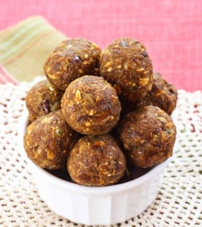 A small white bowl overflowing with Pumpkin Energy Bites.