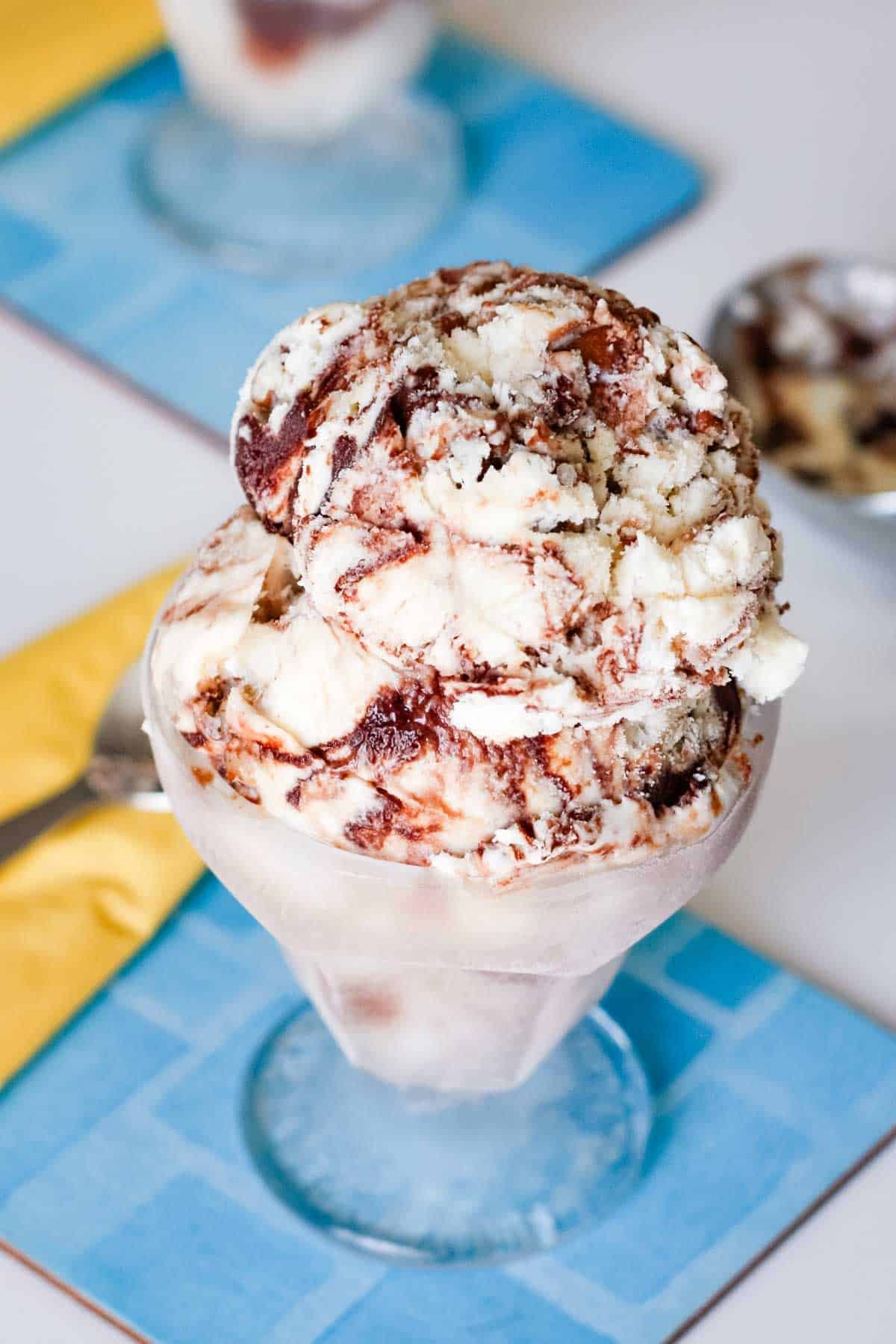 Looking at the top of a dish of butter pecan ice cream with fudge ripples.