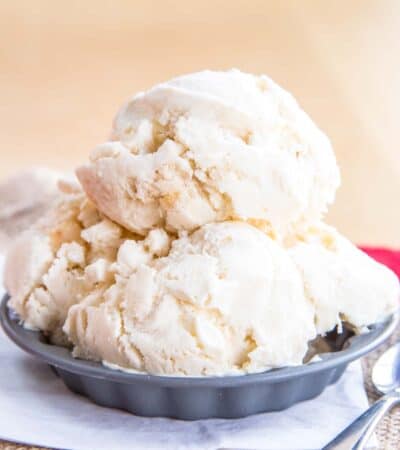 A dish caramel apple ice cream with a small spoon next to it.