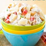 A tropical chicken salad in stacked bowls with text overlay that says "Pineapple Chicken Salad".