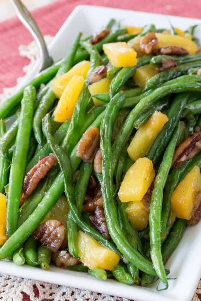 Pineapple Pecan Glazed Green Beans on a white rectangular plate.