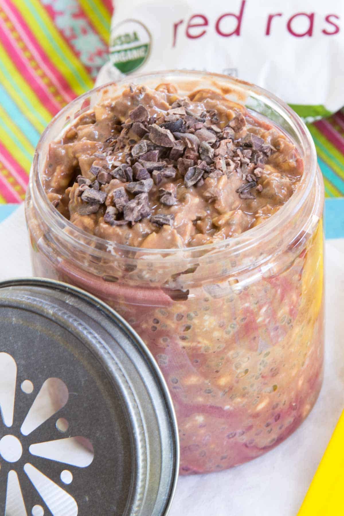 A jar of mocha overnight oats with cacao nibs on top.