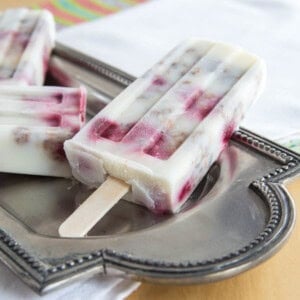 Raspberry yogurt popsicles on a silver platter.