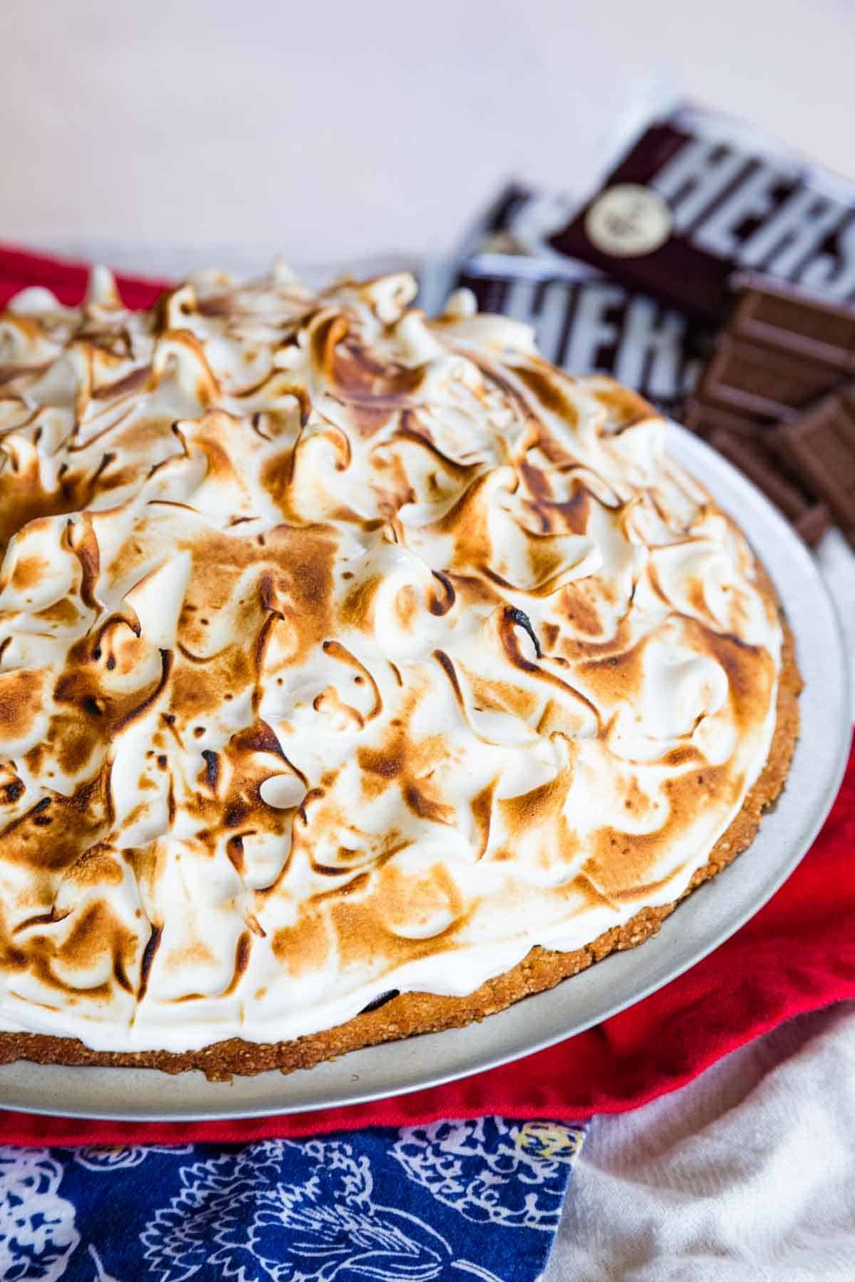 A whole s'mores pudding pie in a pie plate, topped with toasted marshmallow meringue.