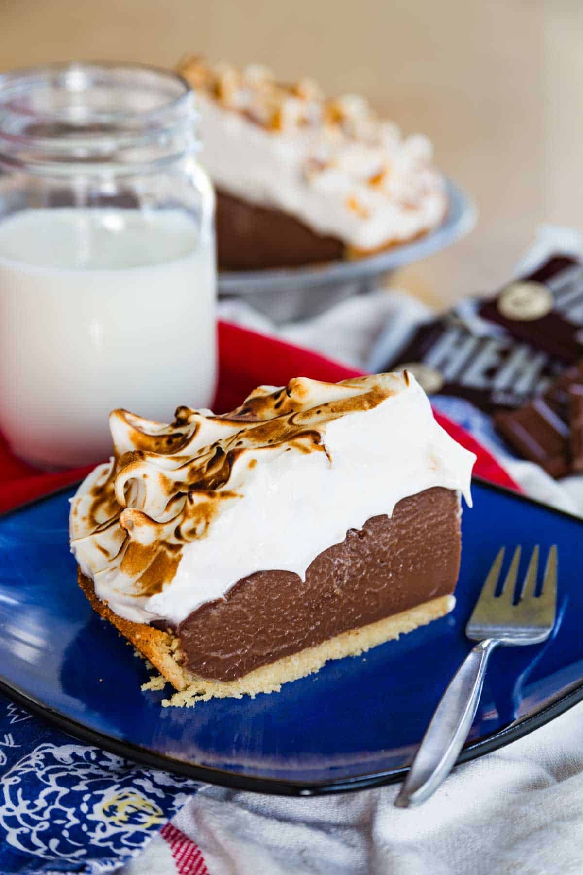 A slice of s'mores pudding pie on a blue plate next to a fork.