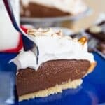 A fork digging into a slice of pudding pie with meringue on top with text overlay that says "Gluten Free S'Mores Pie".