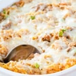 A creamy spaghetti squash bake in a baking dish with a serving spoon in the corner with text overlay that says "Spaghetti Squash Casserole".