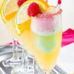 Four Flute Glasses Filled with Sparkling Apple Cider and Scoops of Rainbow Sherbet with text overlay that says "Sparkling Cider Rainbow Sherbet Floats".