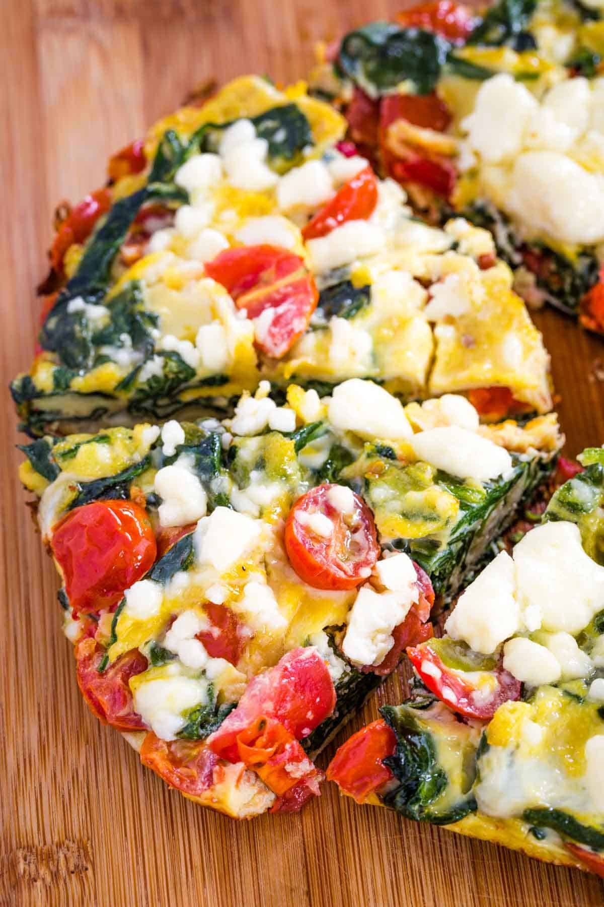 Pieces of Spinach Tomato Frittata from above on a cutting board