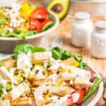 A strawberry mango salad with chicken, avocado, and other ingredients.